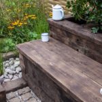 Reclaimed wood bench seating around flowers