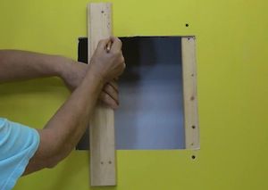 photo marking a furring strip to install in a wall hole