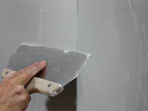 photo smoothing the final coat of joint compound on metal drywall corner bead